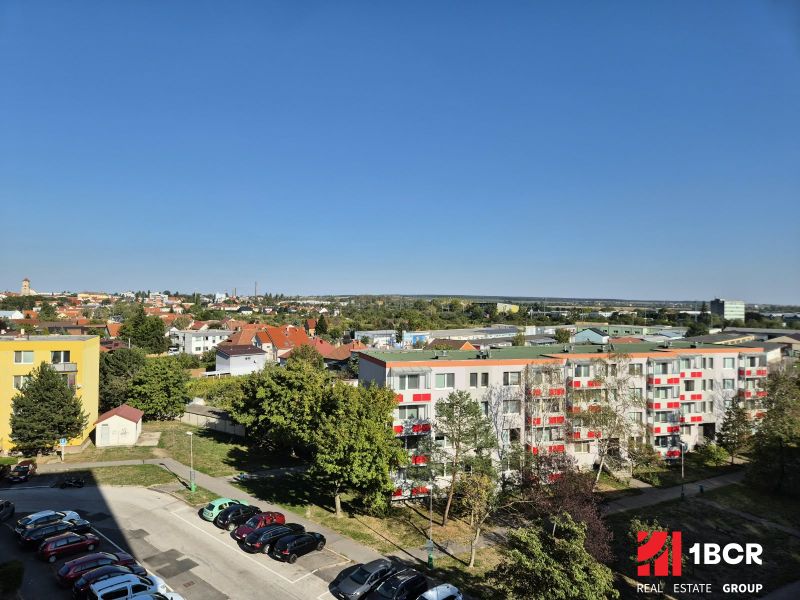 Výhled na Bystrickou ulici v Pezinku s garsonkami a zelení.