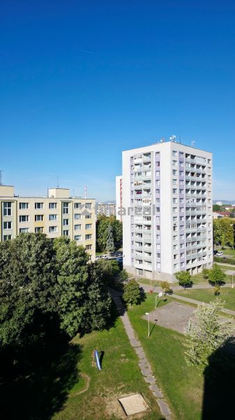 Výhled na bytovky a zeleň v Trnavě, ideální pro 3-pokojový byt.