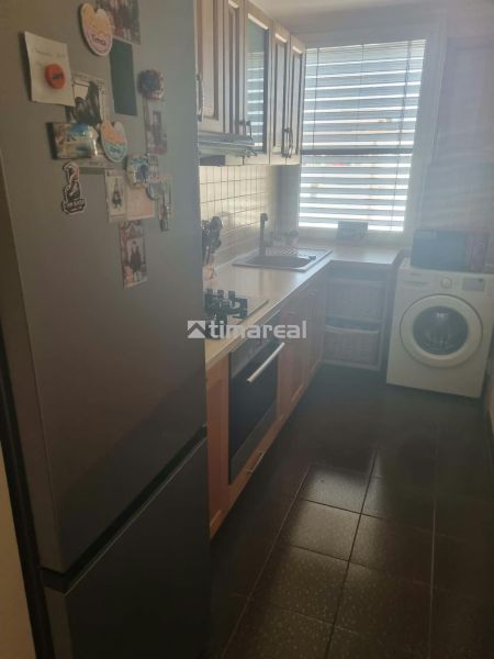 Kuchyně v 3pokojovém bytě s lednicí, sporákem a pračkou.