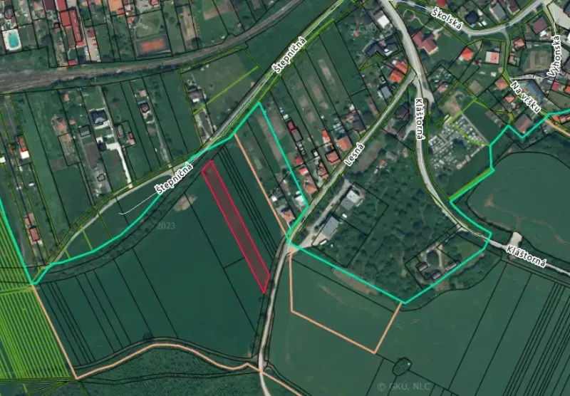 Letecký pohled na zemědělské a lesní pozemky v Podhájske s viditelnou silniční sítí.