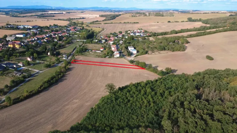 Letecký pohled na zemědělské a lesní pozemky v Podhájské obklopené vesnicí a přírodou.