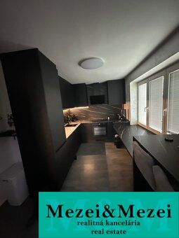 Moderní kuchyně v 2pokojovém bytě s elegantním designem a velkými okny.
