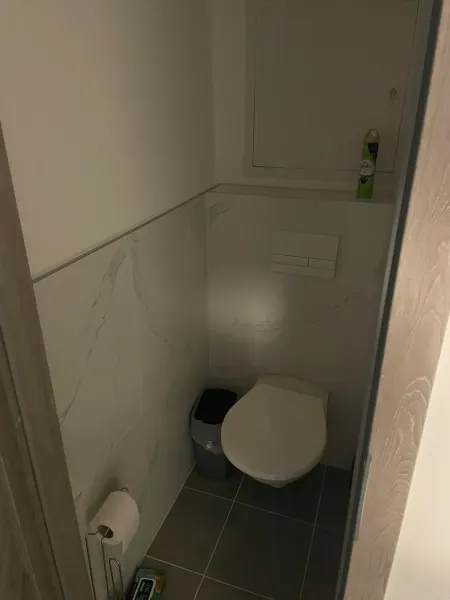 Toaleta s dlaždičkami a osvěžovačem vzduchu v 2-pokojovém bytě.
