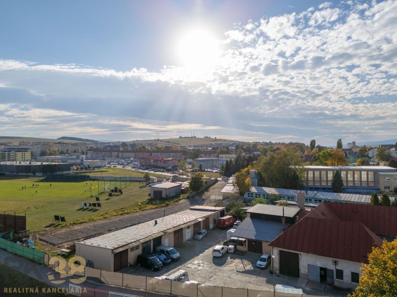 Součástí městské krajiny v Kežmarku jsou garáže a sportovní hřiště pod slunečnou oblohou.