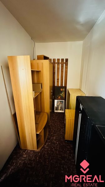 Úložná místnost s dřevěným dekorem, policemi a skříňkami v 3-pokojovém bytě.