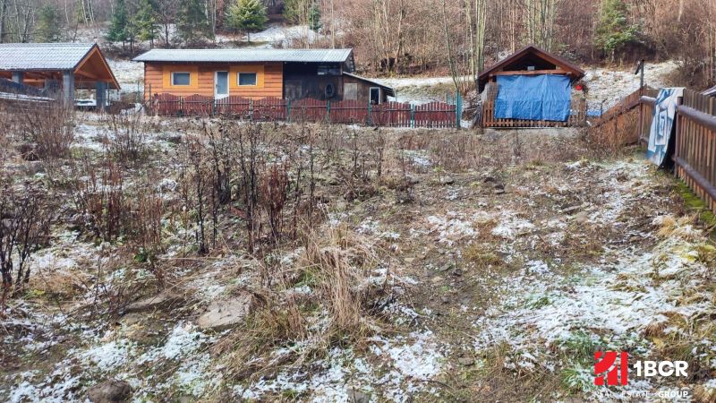 Dřevěné chaty na zasněženém svahu v Oščadnici u rodinného domu.