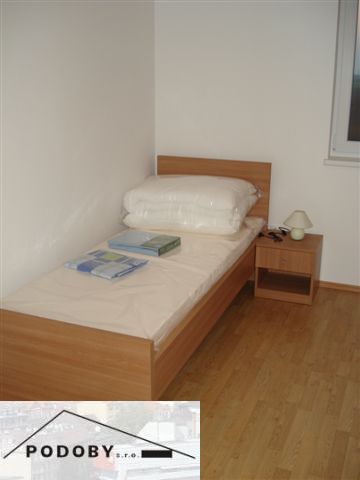 Jednolůžková postel s podlahou s dřevěným dekorem v 3-pokojovém bytě.