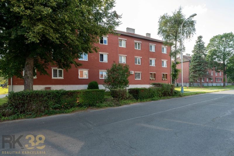 Červená cihlová budova obklopená zelení na ulici 9. května ve městě Svit.