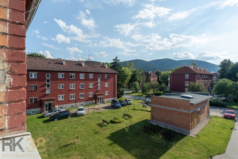 Cihlové budovy s parkovištěm a zelení ve Svitu na ulici 9. května, ideální pro 1-pokojový byt.