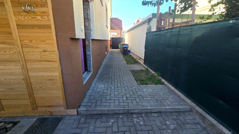 Pavlač u rodinného domu na Kupeckého ulici v Piešťanech s dřevěnými dveřmi.