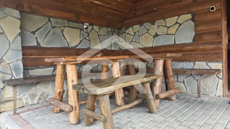 Rustikální koutek s dřevěným nábytkem a kamennou stěnou v Rekreačním apartmánu.