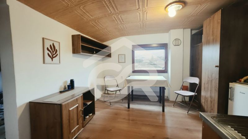 Interiér rekreačního apartmánu s nábytkem s dřevěným dekorem a skládacími židlemi.
