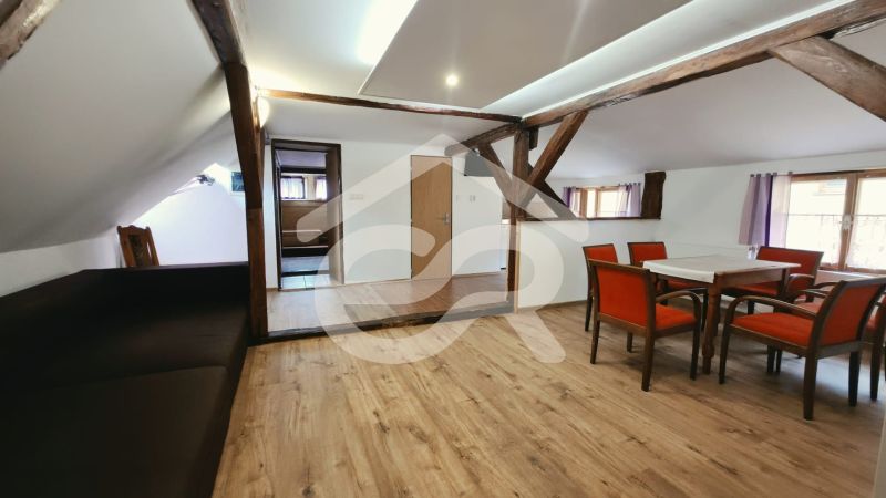 Rekreační apartmán s dřevěnými trámy a podlahou s dřevěným dekorem nabízí jídelní kout.