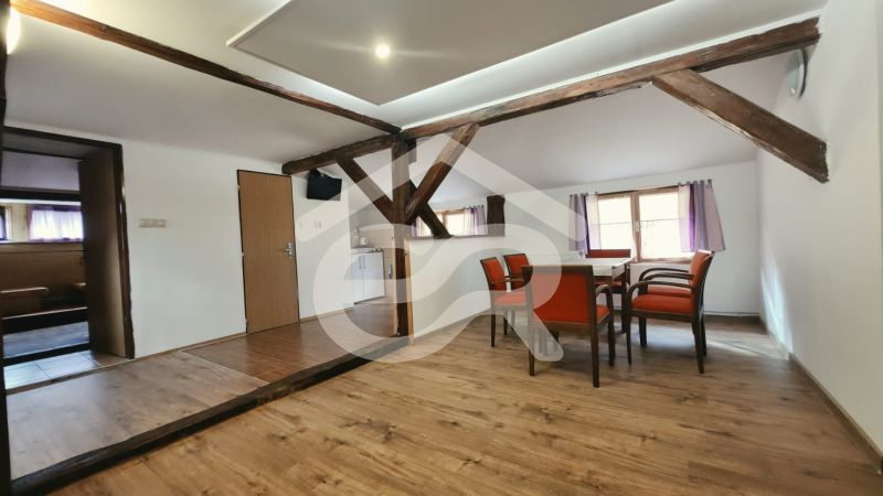 Jídelna s dřevěnými trámy a podlahou s dřevěným dekorem v Rekreačním apartmánu.
