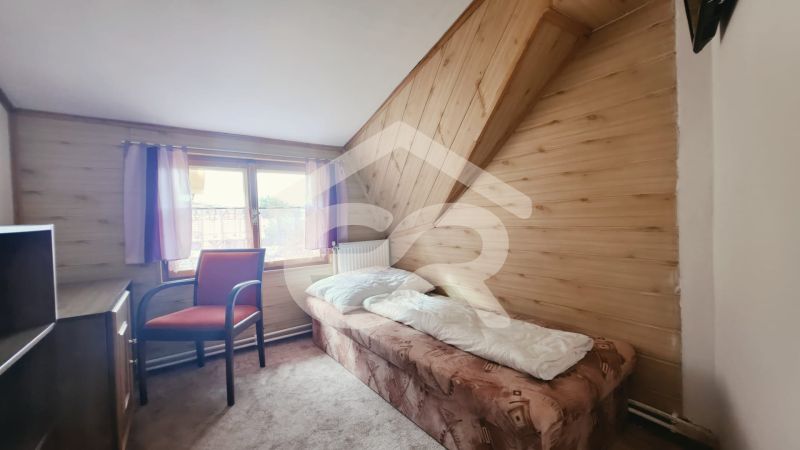 Jednolůžkový pokoj v rekreačním apartmánu s podlahou s dřevěným dekorem a oknem.