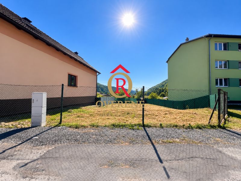 Pozemek k bydlení v Sebedíně-Bečově na ulici Sebedín, oplocený, vedle budov.