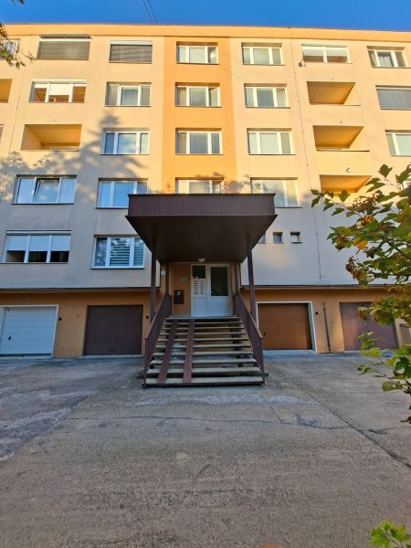 Bytový dům v Prievidzi na ulici Benedikta s garáží a vstupním schodištěm.