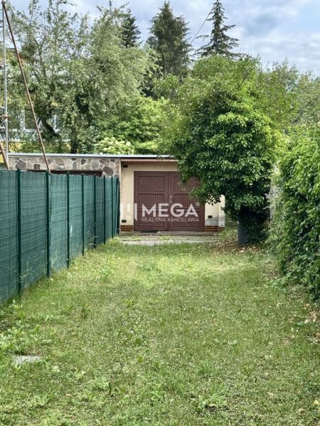 Garáž na ulici Osvoboditelů v Humenném, obklopená zelení a plotem.