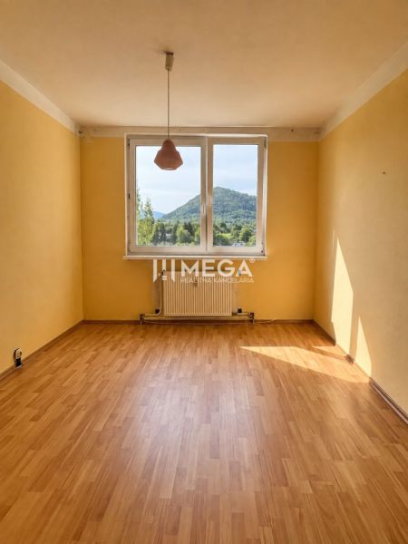 Pokoj ve 3pokojovém bytě s podlahou s dřevěným dekorem a velkým oknem s výhledem.