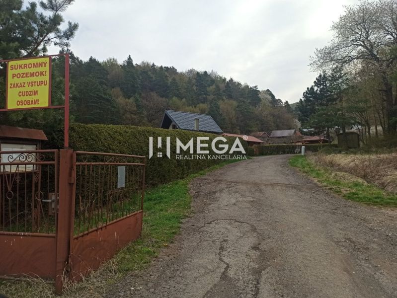 Cesta vedoucí do zahrad v Humenném lemovaná stromy a ploty s tabulí zákazu vstupu.