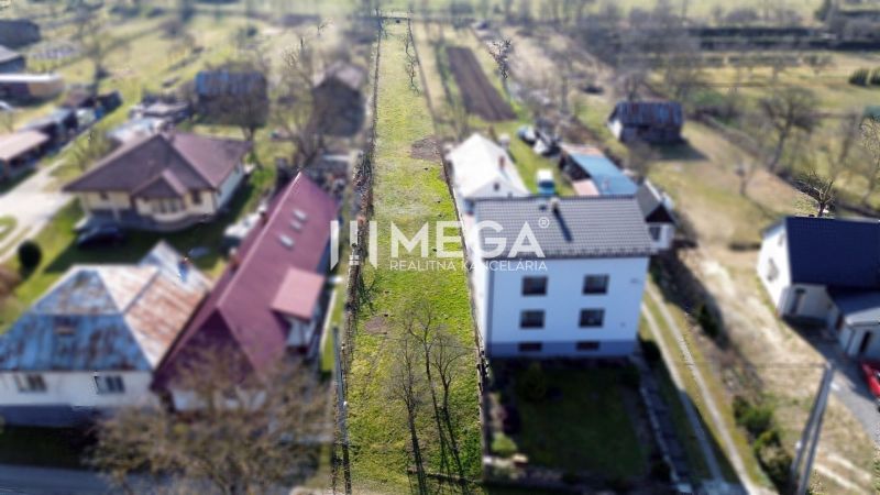Pohled na úzkou parcelu k bydlení v Ptičom na ulici Ptičie, obklopenou domy.