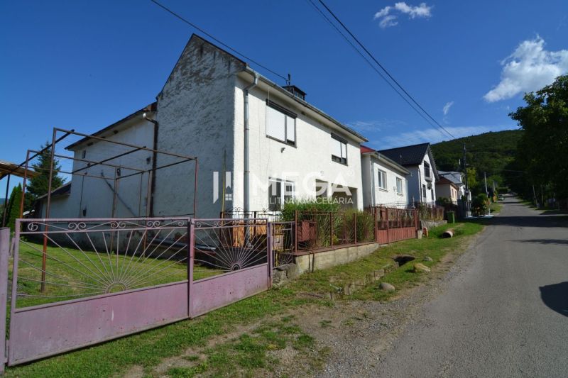 Rodinný dům na ulici v Hažíne nad Cirochou se zahradou a bránou.