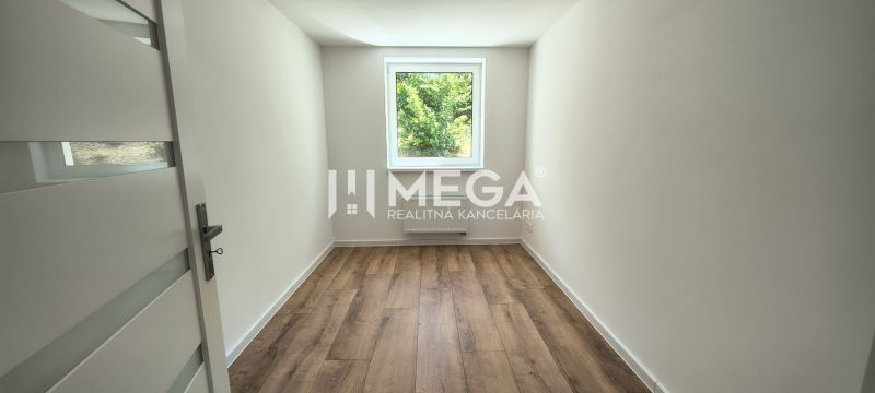 Pokoj ve 4pokojovém bytě s podlahou s dřevěným dekorem a výhledem z okna.