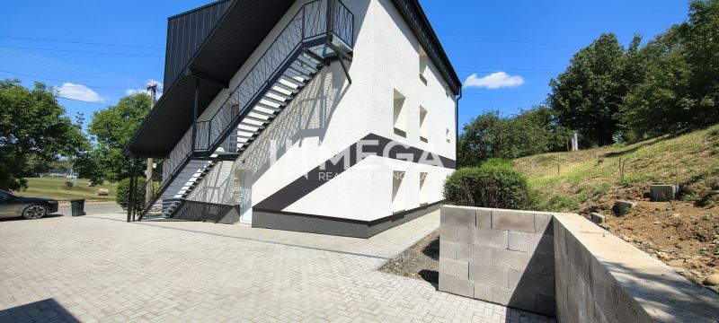 Exteriér budovy v Jasenově s bočními schody a přístupovým chodníkem, vhodný pro 4pokojový byt.