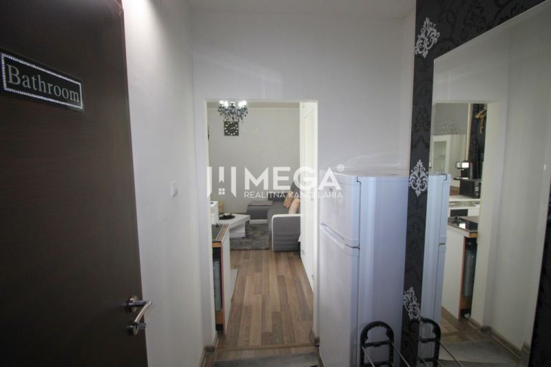 Rekreační apartmán s podlahou s dřevěným dekorem, kuchyňský kout a obývací prostor.
