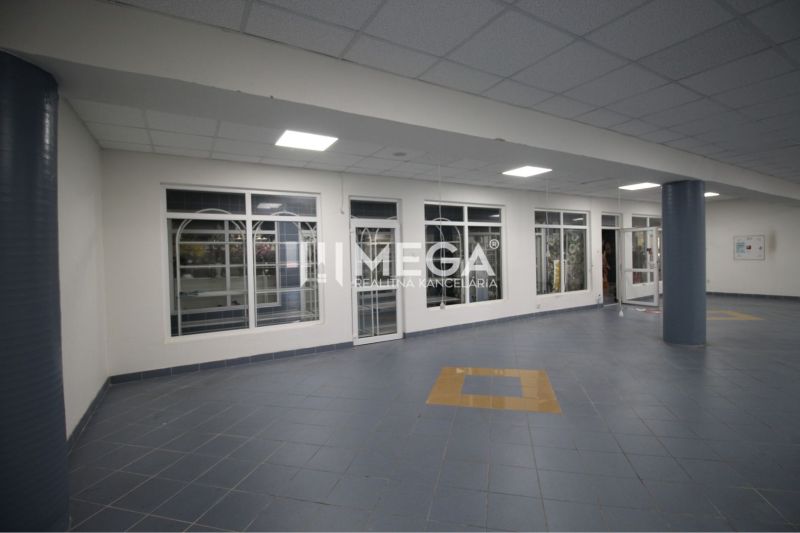 Obchodní prostory se skleněnými dveřmi a modrými dlaždicemi, podlaha s dekorem.