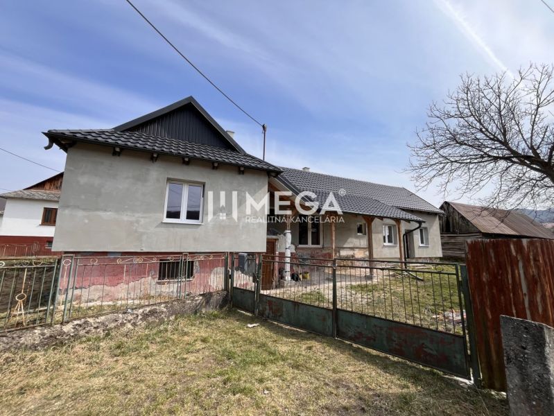 Rodinný dům v obci Pakostov na ulici Pakostov se zahradou a kovovým plotem.