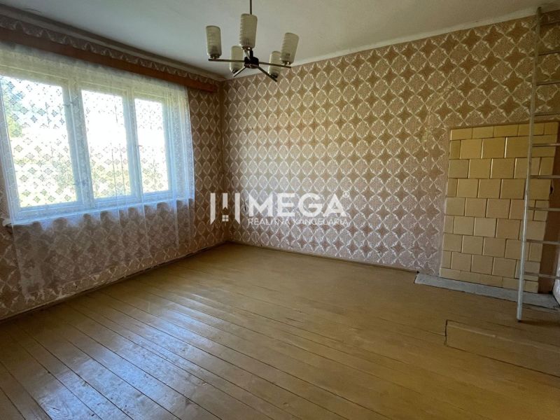 Rodinný dům s podlahou s dřevěným dekorem, vzorovanými tapetami a velkým oknem.