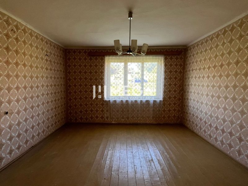 Pokoj s tapetami a podlahou s dřevěným dekorem v rodinném domě.