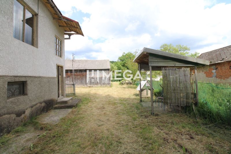 Zahrada u rodinného domu v obci Zbudská Belá, s přístřeškem a dřevěnou stavbou.