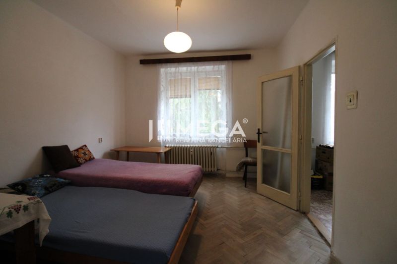 Ložnice s dvěma postelemi a podlahou s dřevěným dekorem v 2-pokojovém bytě.