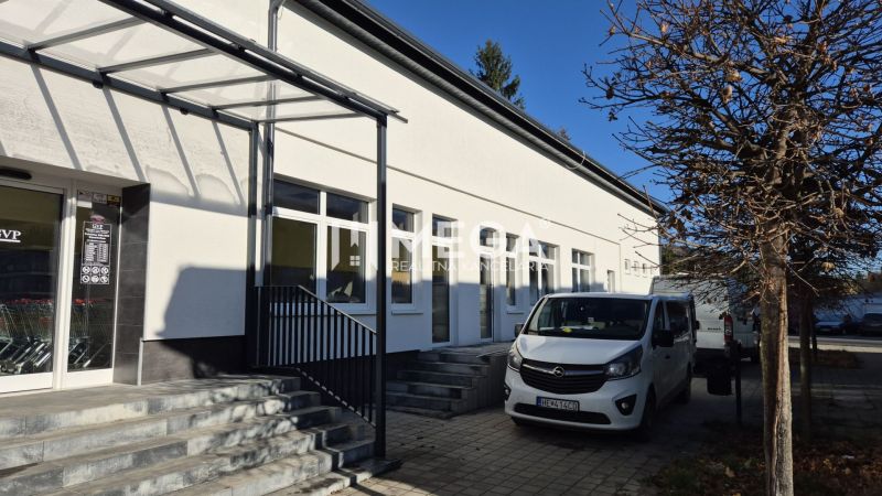 Budova s obchodními prostory na Tyršově ulici v Humenném, zaparkovaná auta, strom.