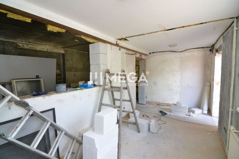 Výrobní prostory ve výstavbě s žebříkem a stavebním materiálem, podlaha s dřevěným dekorem.