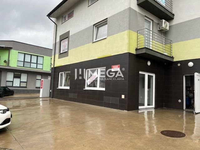 Obchodní prostory na Komenského ulici v Snině s moderní fasádou a balkónem.