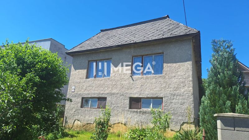 Rodinný dům na Jesenského ulici ve Snině, obklopený zelení a stromy.