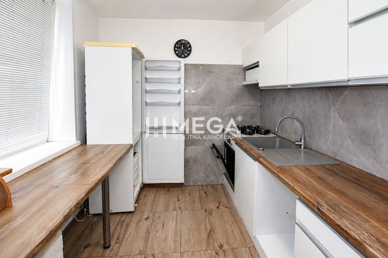 Kuchyně ve 3pokojovém bytě s podlahou s dřevěným dekorem a elegantní kuchyňskou linkou.