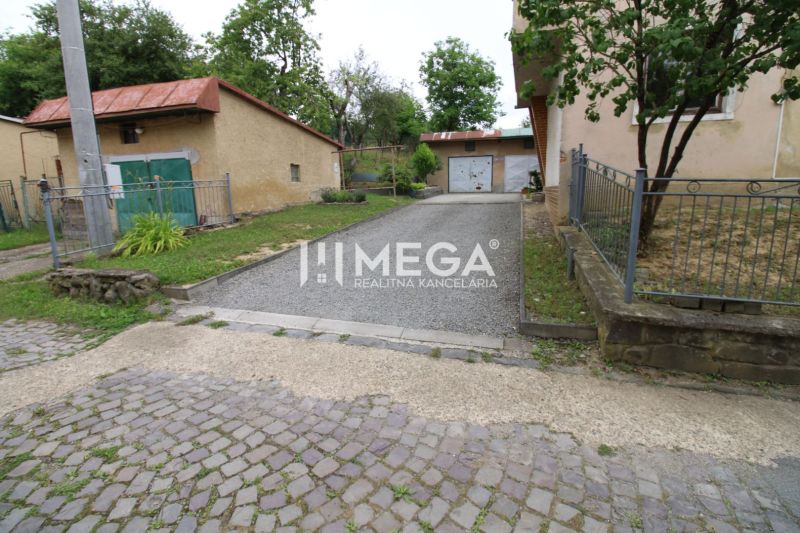 Exteriér 5 a více pokojového bytu na Gagarinově ulici v Snině, s garáží a příjezdovou cestou.