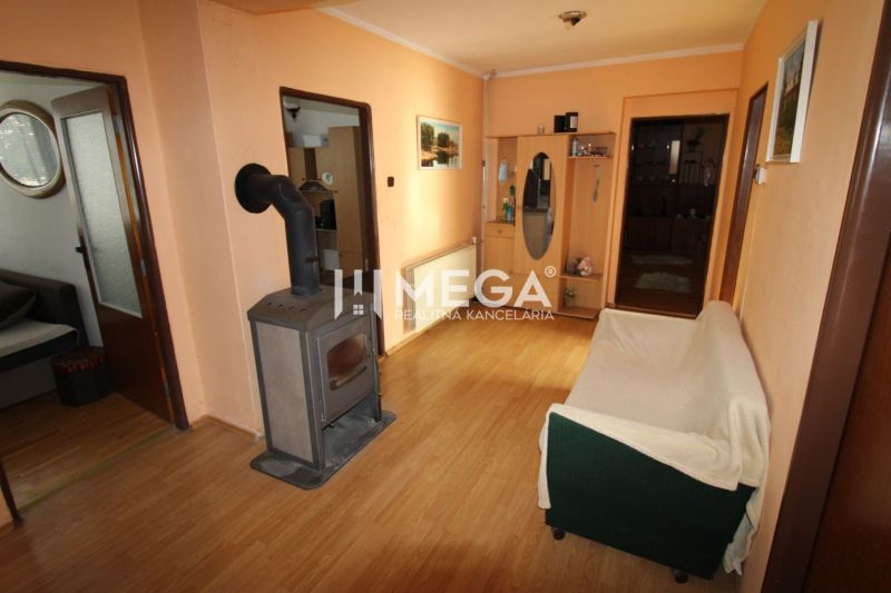 Interiér rodinného domu s kachlemi a podlahou s dřevěným dekorem.
