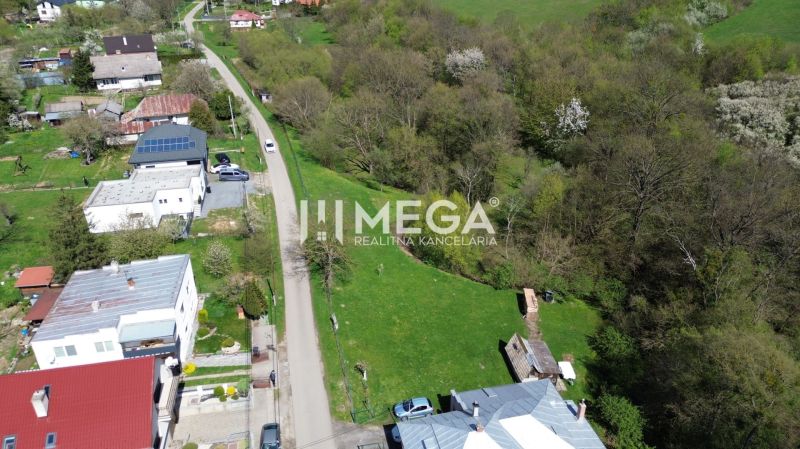 Pozemky - bydlení na Starých cestách ve Starém, obklopené zelení a domy.