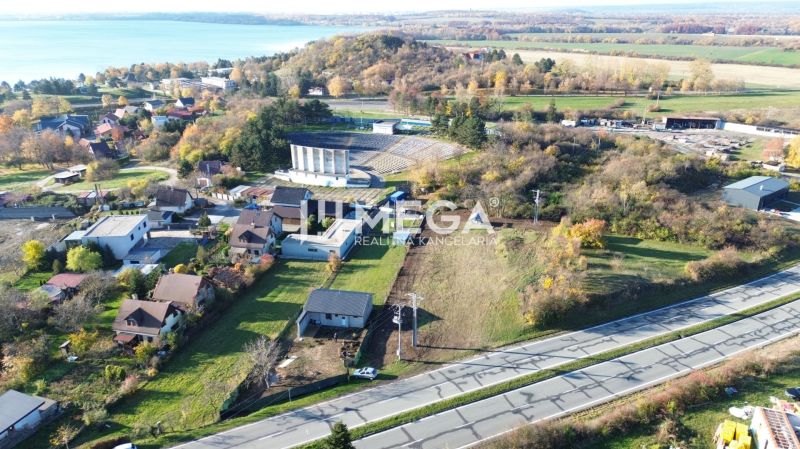 Panoramatický výhled na pozemky k bydlení ve Vinném s blízkým jezerem.