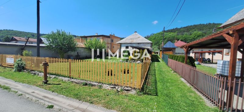 Rodinný dům v Kochanovcích na ulici Kochanovce s předzahrádkou a dřevěným plotem.