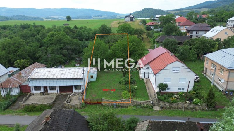 Pozemek v Oľšinkově vhodný k bydlení, obklopený zelení a nedalekými domy.