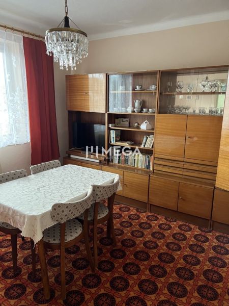 Jídelna v rodinném domě s retro nábytkem, koberec, lustr, záclony.