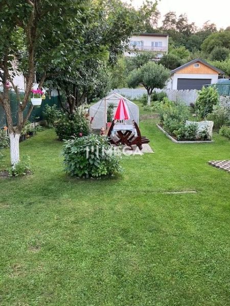 Zahrada rodinného domu na Jesenského ulici ve Snině s altánkem a rostlinami.
