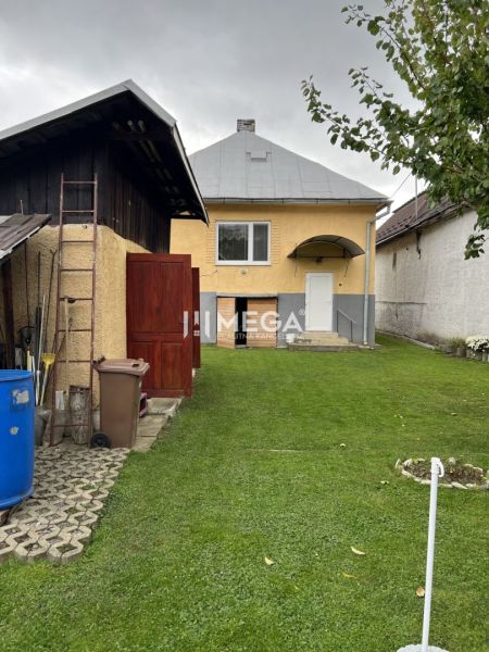 Rodinný dům na Jesenského ulici v Snině, se zeleným trávníkem a příslušenstvím.