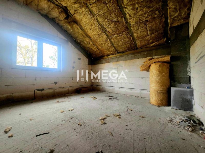 Interiér rodinného domu s nedokončenou místností a izolačním materiálem na podlaze.